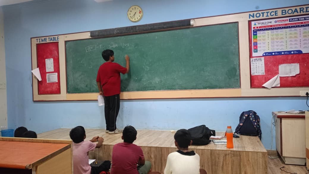 A student teaching classmates at the front of a classroom during peer learning